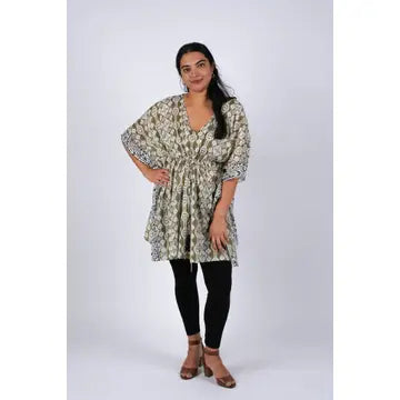 Woman posing in olive green Aztec ikat print kaftan, hands on hips, full length front view
