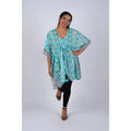 Woman wearing teal Aztec ikat print kaftan with gathered waist and dolman sleeves, front view