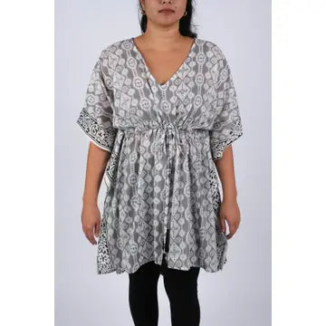 Woman wearing grey Aztec ikat print kaftan with gathered waist, front view