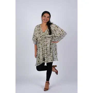 Woman smiling in olive green Aztec ikat print kaftan, full length front view