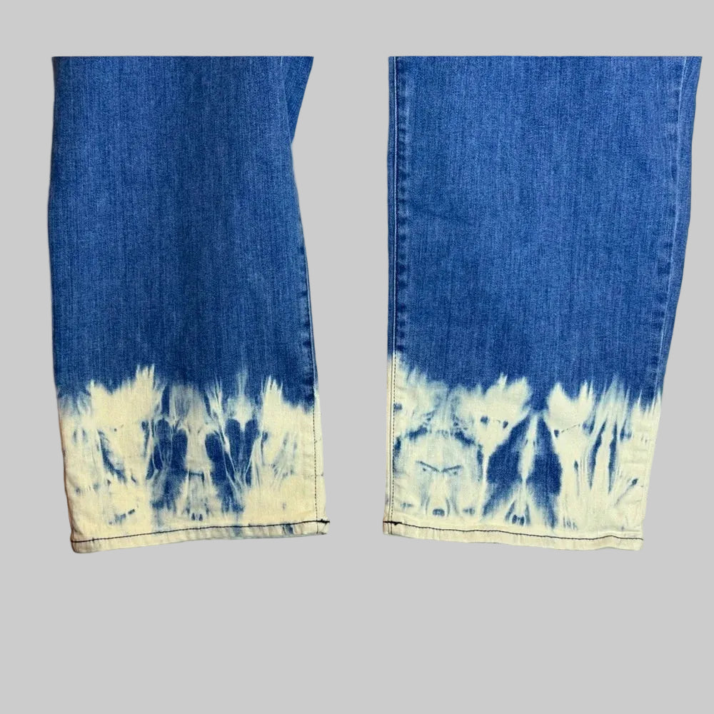 Two denim scarves with tie-dye patterns on a wooden surface