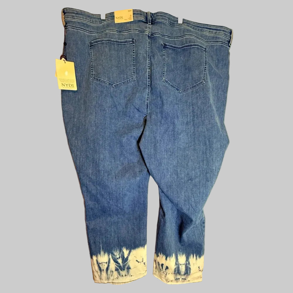Pair of blue jeans with a yellow tag on a wooden surface