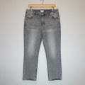 Pair of gray acid-wash jeans on a wooden surface