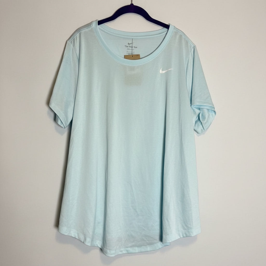 A light mint green Nike short-sleeve athletic t-shirt hanging on a dark hanger against a rustic whitewashed wood plank background.