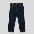 Pair of dark blue jeans hanging on a wooden surface