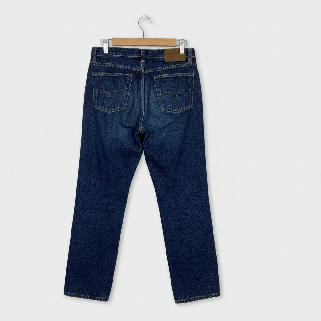 Pair of blue jeans hanging on a wooden surface