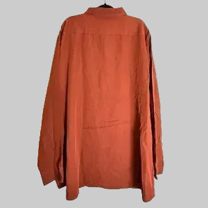 A rust-orange long-sleeve button-up shirt with a mock neck, hanging on a black hanger against a white wood-plank background.